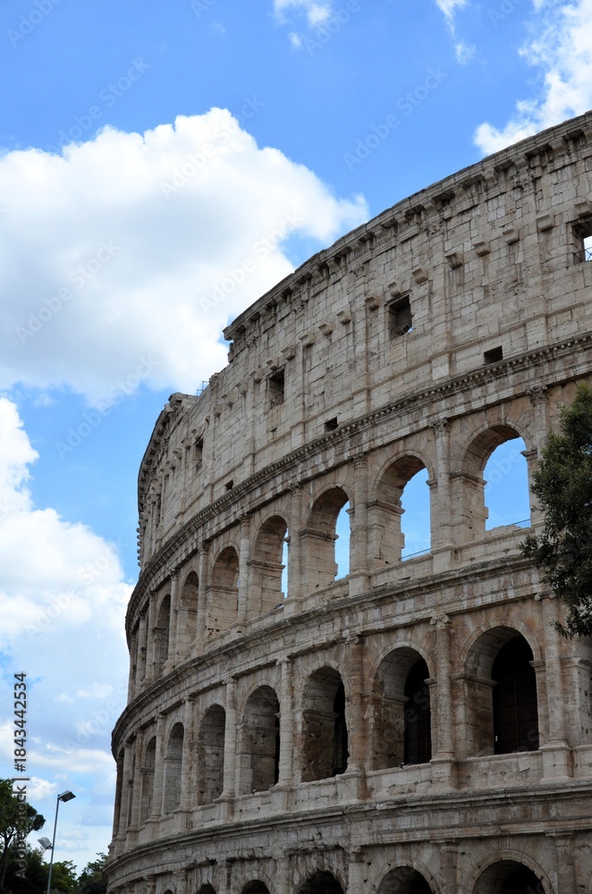 Fototapeta premium Rome, Italy 09.02.2019: Colosseum (Coliseum) is one of main travel attraction of Rome, Italy. Ancient Roman ruins of Colosseum, landscape of old Rome city, Italy.