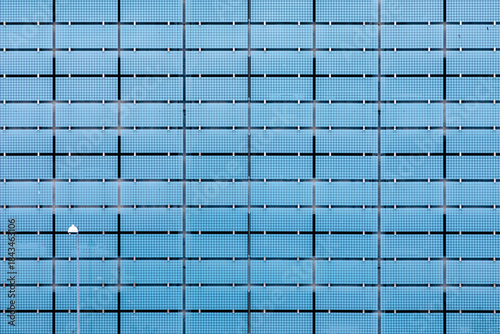 Blue glass building facade with grid pattern and subtle reflections