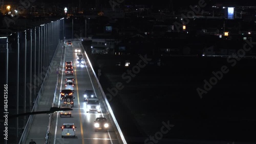 河川にかかる橋の上を車が走る夕方から夜の風景
