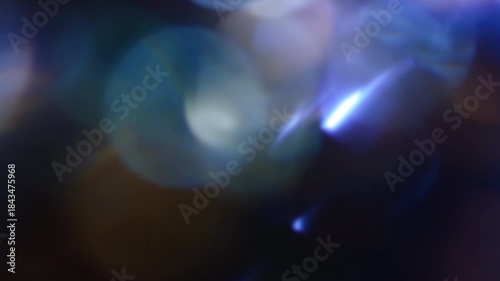Blue and orange blurred bokeh lights on dark abstract background, soft glowing shapes in real 4K UHD video loop, ideal for cinematic overlays, parties and festive motion design