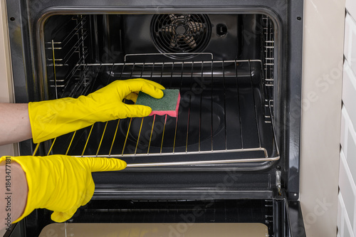 Billede på lærred Washing and scrubbing the inside of the kitchen oven