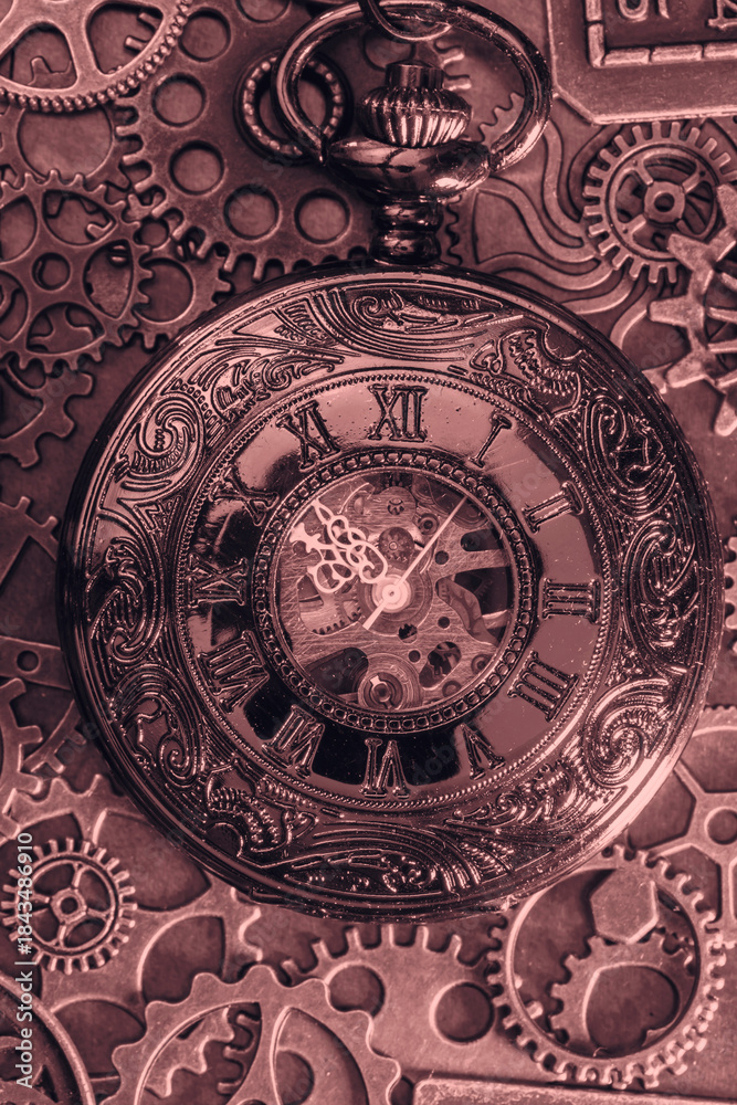 Obraz premium Copper antique pocket fob watch with gears and cogs in the background. Vintage industrial steampunk fashion accessories.
