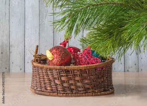 Merry Christmas greeting card; Vintage basket with christmas decoration, pine branch on a wooden background