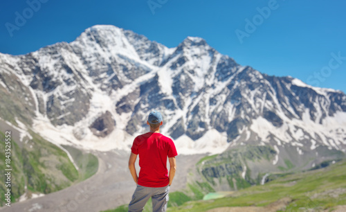 Cuadro en lienzo Man in red t-shirt stand and look on the snow mountain.