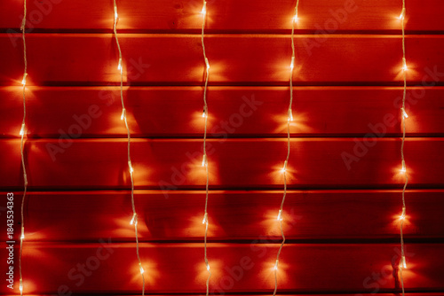 Fotografi Garland on red wall, minimalist Christmas background and texture
