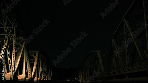 夜空に光跡を残して走る列車と鉄橋の夜景
