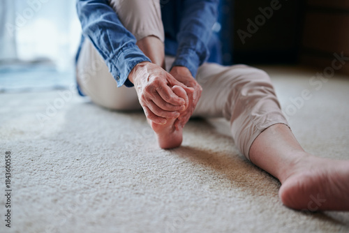 足をマッサージする冷え性のシニア女性