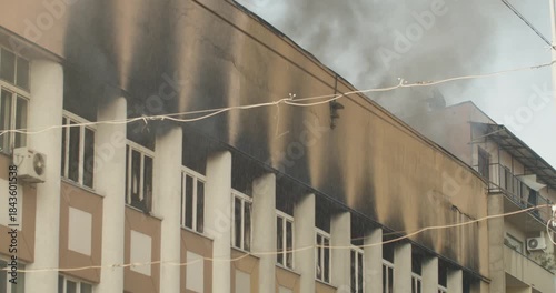 Fireman extinguishing fire with a water gun on the roof of a burning building