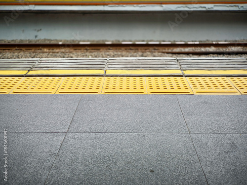 Tableau sur toile Yellow tactile paving on train station platform edge for safety