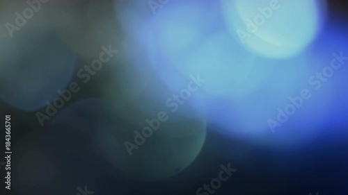 Blue blurred bokeh lights on a dark abstract background, soft glowing circles in real 4K UHD video loop, ideal for festive overlays, parties, celebrations and elegant motion design