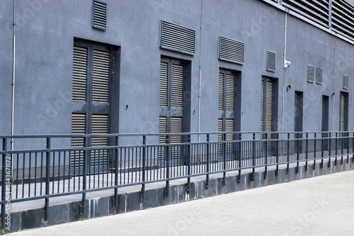 Industrial gray exterior, Urban scene featuring minimalist architecture and stark midday shadows