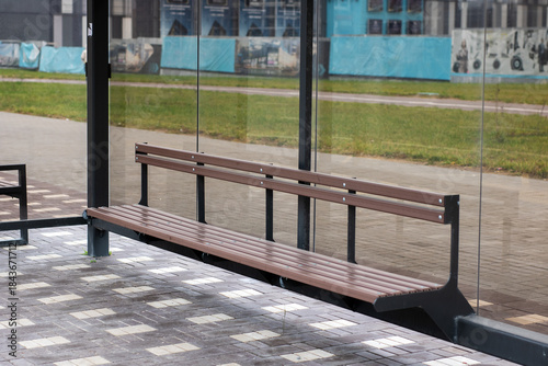 Modern shelter with reflective glass, Bus shelter featuring glass panels and artistic murals