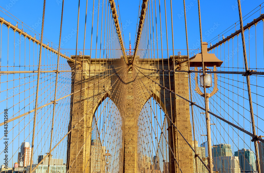 Fototapeta premium View from Brooklyn Bridge showing cables stone structure under clear blue sky