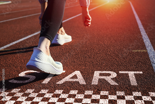Runner is preparing to take step forward on track with word START. conveys the inspirational concept of starting a business and career path.