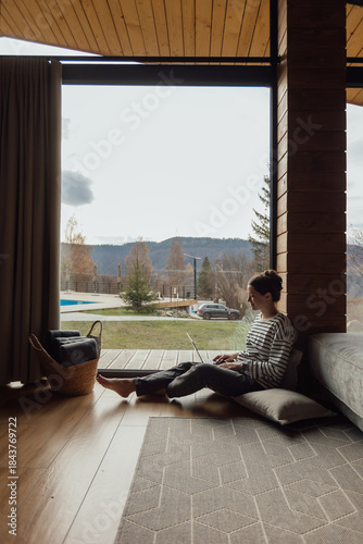 Cozy work space with a woman using a laptop by the window