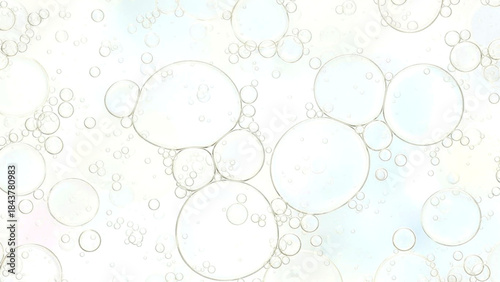 Transparent bubbles floating on a soft pastel colored background with various sizes and shapes
