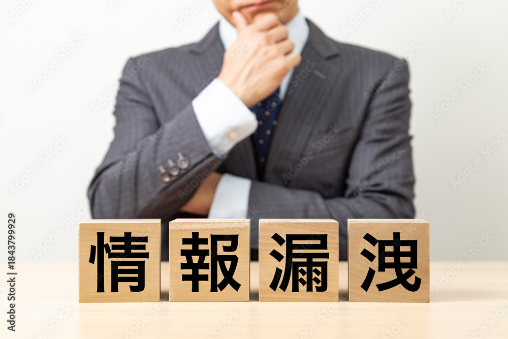 Obraz premium 「情報漏洩」と書かれたブロックとビジネスマン