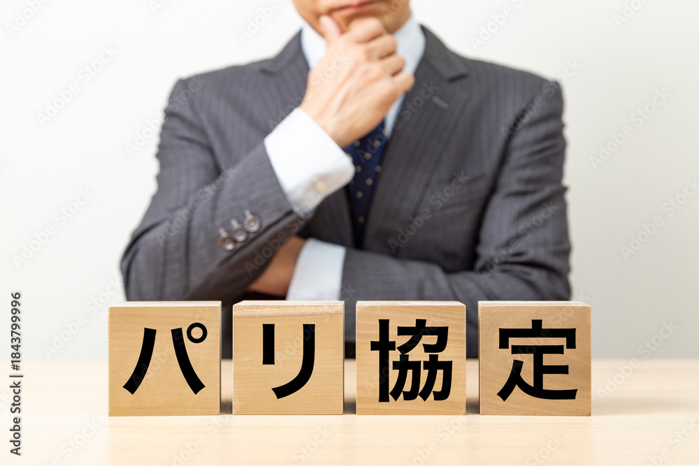 Obraz premium 「パリ協定」と書かれたブロックとビジネスマン