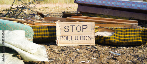 Foto Cardboard sign calling to stop pollution in landfill