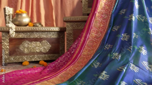 Tracking shot of blue silk Indian saree draped on a stool captured in detailed 4K footage showcasing elegant textile movement