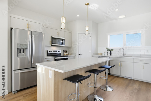 Kitchen with a white island and black stools