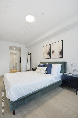 Large bed with a green headboard and white pillows