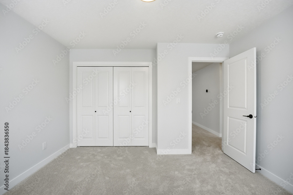 Fototapeta premium White bedroom with a white door and white closet