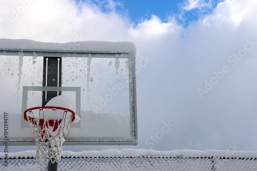 Foto Basketball hoop in winter covered in heavy snow.