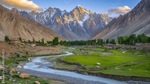 Majestic Snow-Capped Peaks Tower Over a Serene Valley with a Winding River and Rustic Village