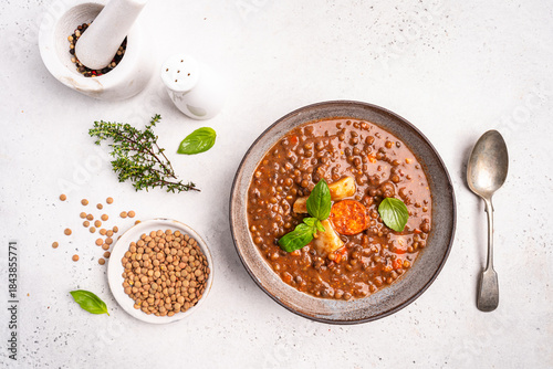 Traditional Spanish dish of lentil stew with chorizo and potatoes on a white background. Top view composition. . High quality photo