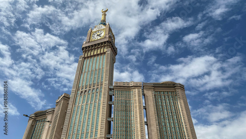 Obraz na plátně Low-angle view of the Abraj Al Bait complex featuring the Makkah Clock Royal Tower, one of the world's tallest buildings, under a cloudy sky in Mecca, Saudi Arabia