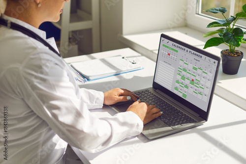 Tableau sur toile Doctor in office using laptop calendar schedule