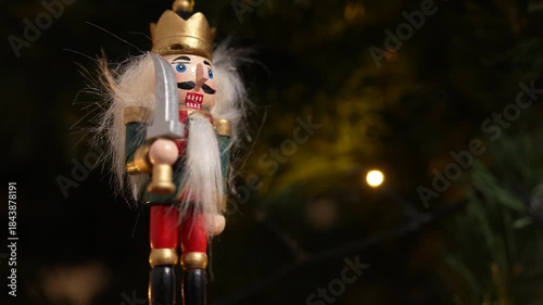 A nutcracker soldier ornament with a Christmas tree visible in the background, symbolising holiday tradition and festive Christmas spirit. 4 k video
