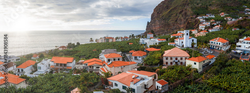 Εκτύπωση καμβά Whitewashed houses with orange roofs sit by green terraces and a rugged cliff beside the Atlantic