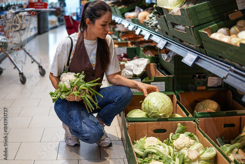 Bilde på lerret dark-haired middle-aged woman shopping for fruits and vegetables in a supermarke