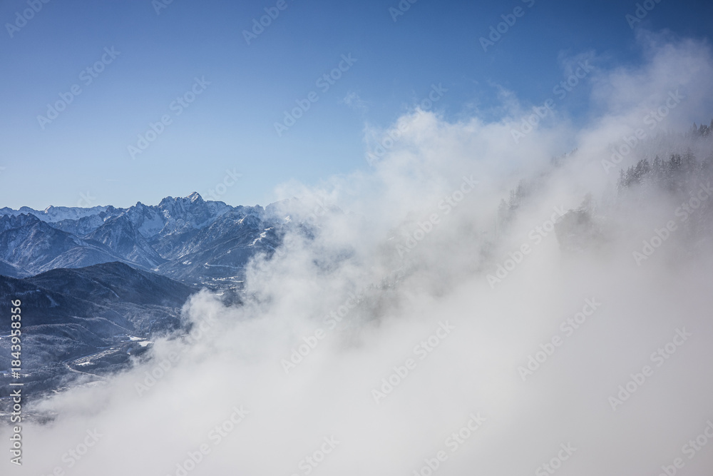 Naklejka premium Beauty of the winter Alps seen through rising fog, Austria, with mesmerizing mountain peaks
