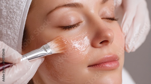 Closeup of relaxed woman face during chemical peeling procedure applied by therapist hands, Skin care and SPA concept.