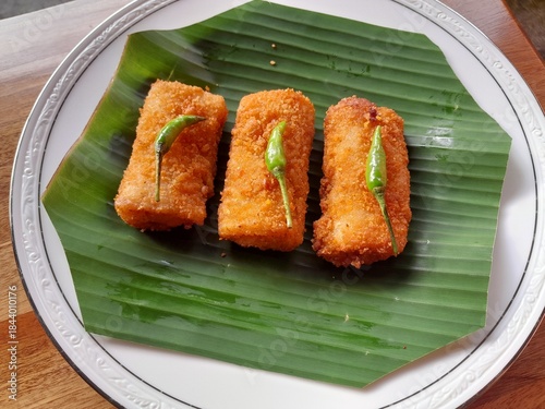 Three neatly arranged mayo risoles served on a banana leaf base