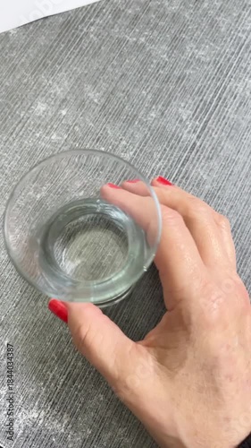 Waiting to be filled: Woman holding a simple, empty drinking glass