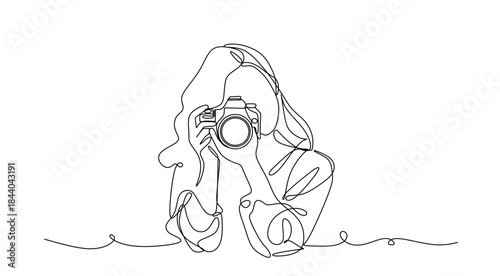 Continuous line drawing of a woman holding a camera up to her face taking a photograph in black and white