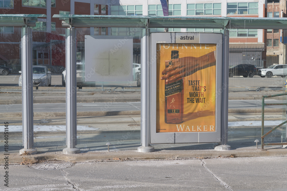 Fototapeta premium public transit streetcar shelter with street poster for Walker alcohol, Queens Quay W, Toronto