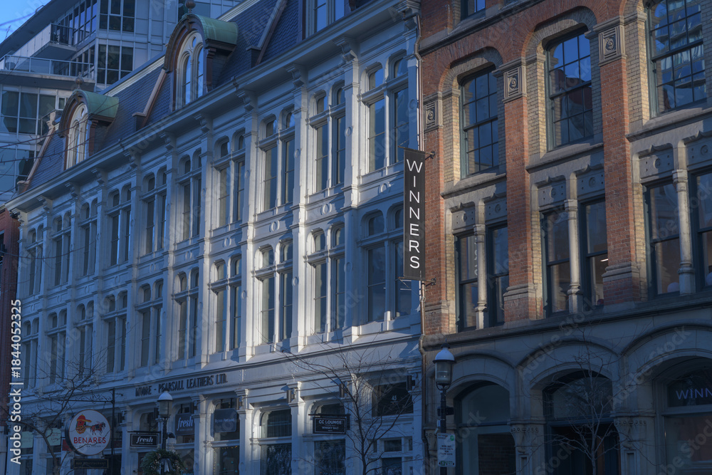 Fototapeta premium facade of historic buildings incl projecting banner sign of Winners, a department store, located at 45 Front St E, Toronto