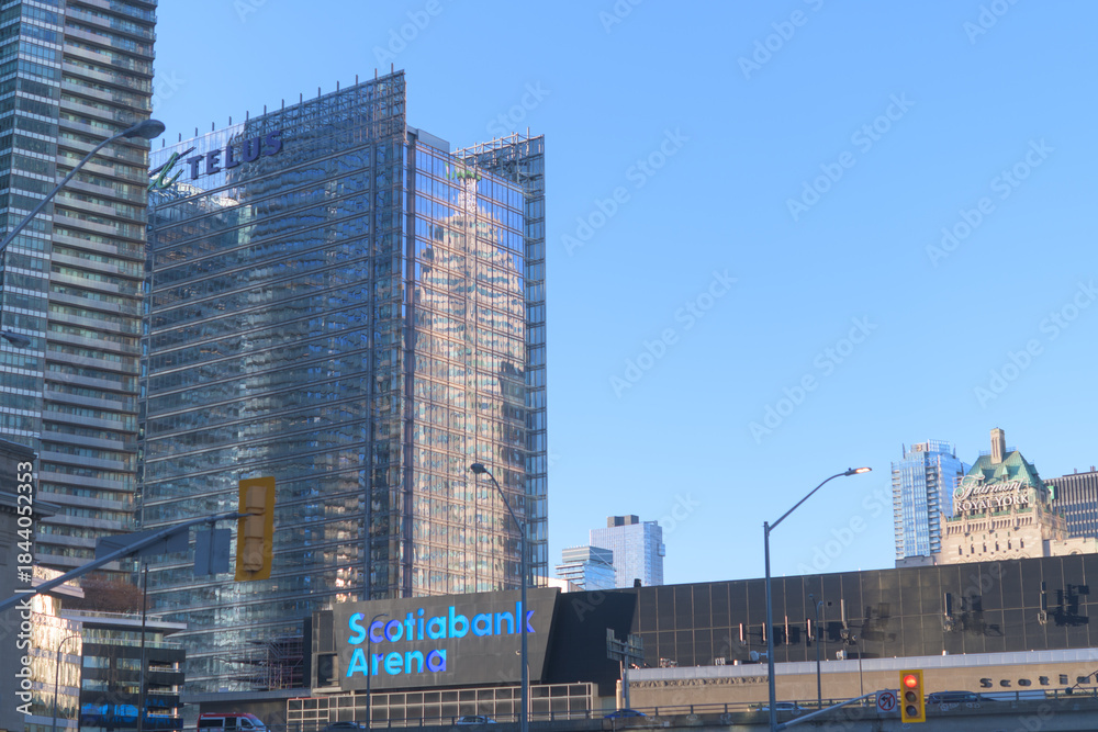 Fototapeta premium reflection of TD Canada Trust Tower on the east elevation of the Telus Building with view of Scotiabank Arena on a blue sky in Toronto