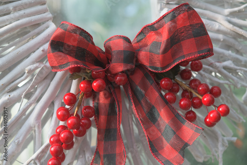 red berries and plaid bow on a contemporary twig wreath