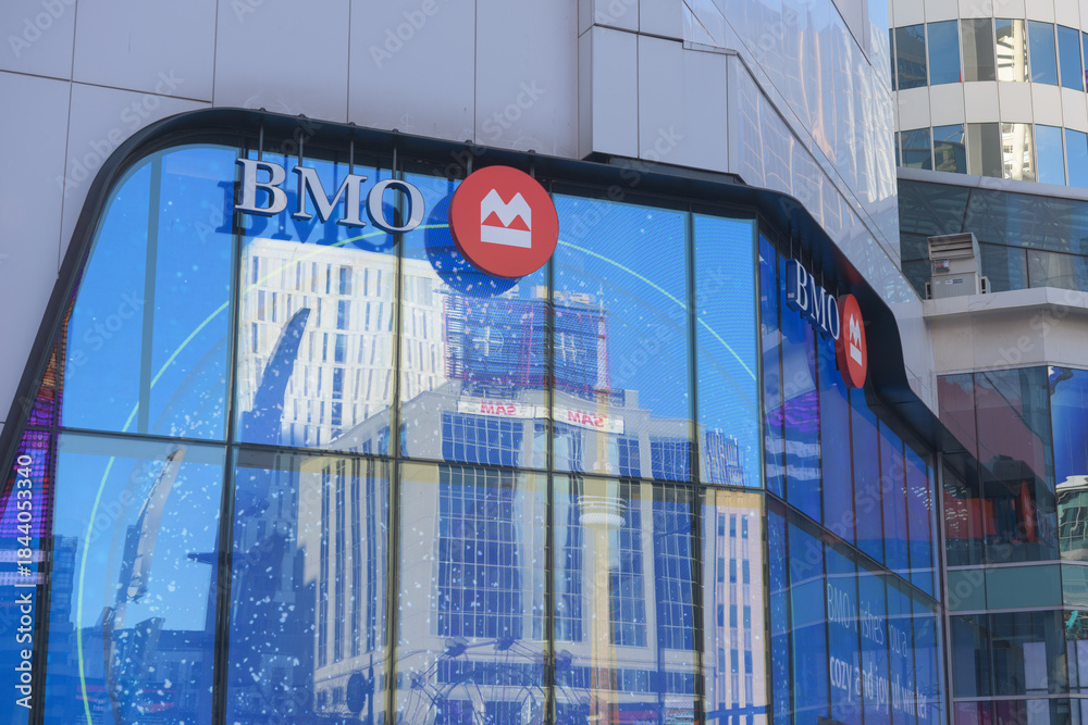 Naklejka premium exterior building facade and sign of BMO Bank of Montreal with reflection of buildings facing Sankofa Square, located at 220 Yonge St, unit 302, Toronto