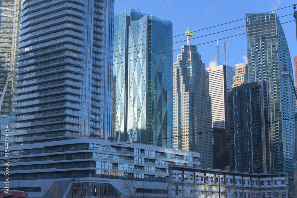 Fototapeta premium cluster of modern office buildings and residential skyscrapers viewed from Queens Quay E (incl: The Prestige at Pinnacle One Yonge, CIBC Square, TD Canada Trust Tower, First Canadian Place, and L-Towe