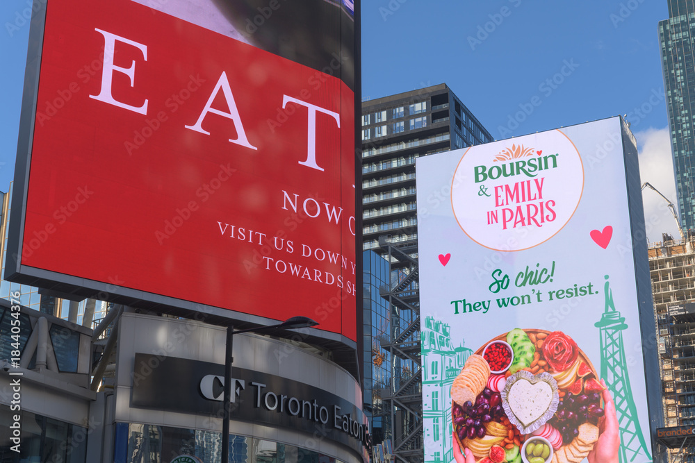 Naklejka premium digital display at Sankofa Square featuring ads for Eataly Eaton Centre and Boursin, cheese product, and Netflix rom-com promotion for 