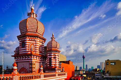 Spectacular view of the historic Minarets of the Jami Ul Alfar Mosque in contrast with the landmark 351m tall Lotus Tower with bright blue skies in Colombo,Sri Lanka