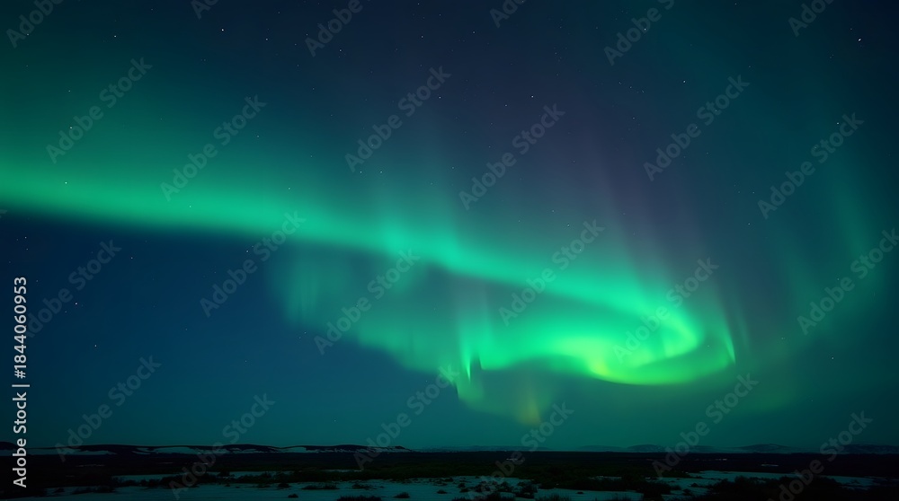 Naklejka premium Mesmerizing display of the Aurora Borealis illuminating the dark night sky over a serene, snow-covered winter landscape, showcasing nature's vibrant light show