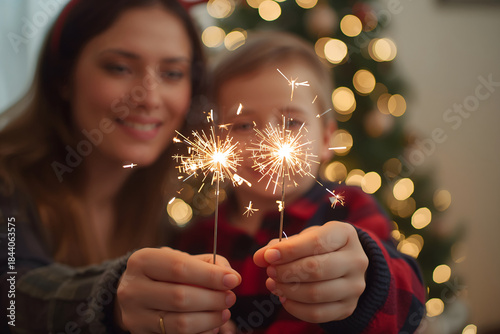 Joyful mother and child holding sparkling sparklers during festive holiday celebration with glowing lights